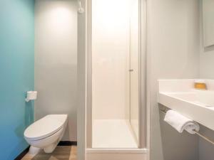 Baño blanco con aseo y lavamanos en ibis budget Forbach Centre, en Forbach