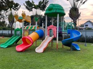 un parque infantil con diferentes toboganes de colores en el césped en Baanmai, Chiangrai House en Ban Pa Tung (7)