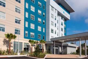 an office building with palm trees in front of it at Hyatt House Orlando Airport in Orlando