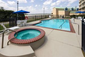 a swimming pool with chairs and an umbrella at WaterView Casino & Hotel, Trademark Collection by Wyndham in Vicksburg