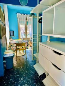 una cucina con pareti blu e un tavolo in una stanza di GUEST HOUSE SONNINO 37 a Cagliari