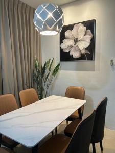 comedor con mesa blanca y sillas en Amy*Home2 @Roxy Apartmnt Kuching, en Kuching