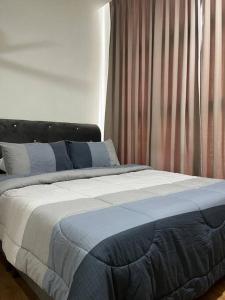 1 dormitorio con 1 cama con sábanas azules y blancas en Amy*Home2 @Roxy Apartmnt Kuching, en Kuching
