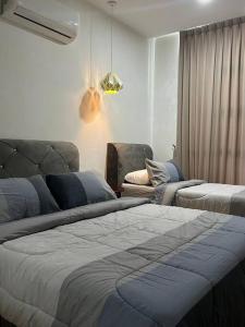 sala de estar con 2 camas y sofá en Amy*Home2 @Roxy Apartmnt Kuching, en Kuching