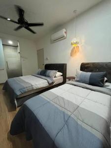 1 dormitorio con 2 camas y ventilador de techo en Amy*Home2 @Roxy Apartmnt Kuching, en Kuching