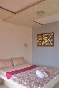 een slaapkamer met een bed met een schilderij aan de muur bij Azzura Hotel in Zamboanga