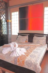 een slaapkamer met een groot bed met twee poppen erop bij Azzura Hotel in Zamboanga