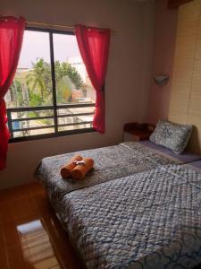 een slaapkamer met een bed en een raam met rode gordijnen bij Azzura Hotel in Zamboanga
