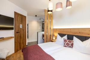 a bedroom with a white bed with a wooden headboard at Holzlodge deluxe in Radstadt