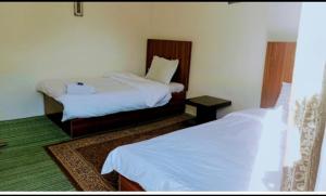 a hotel room with two beds in a room at Backpackers Stories by Old Hunza Inn in Hunza Valley