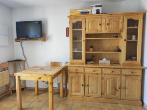 a wooden cabinet and a table in a room at Appartement les Angles in Les Angles