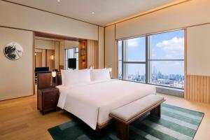 a bedroom with a large bed and a large window at Artyzen NEW BUND 31 Shanghai Qiantan in Shanghai