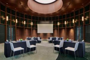 a conference room with tables and chairs and a projection screen at Artyzen NEW BUND 31 Shanghai in Shanghai