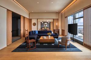 uma sala de estar com um sofá azul e uma televisão em Artyzen NEW BUND 31 Shanghai Qiantan em Xangai