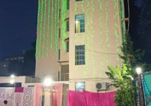 ein hohes Gebäude mit grüner Beleuchtung an der Seite in der Unterkunft Maa Jagdamba Palace Bihar in Samastīpur