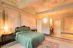 a bedroom with a bed with a green blanket at Palazzo Piazza Mazzini in Pescia