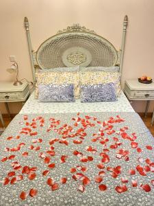 Un letto con un mazzo di rose rosse sopra di Vintage suites a Valongo