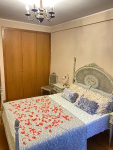 una camera da letto con un letto con fiori rossi di Vintage suites a Valongo