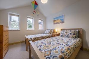 a bedroom with two beds and a kite in the ceiling at Mill House Cottage in Brancaster