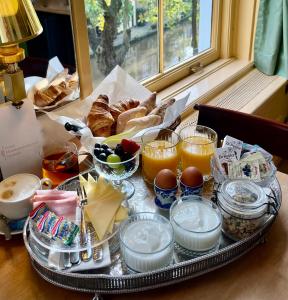 a tray with breakfast foods and drinks on a table at Boutique Hotel Museumkwartier in Utrecht