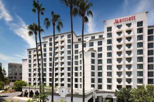 a large white hotel with palm trees in front of it at Costa Mesa Marriott in Costa Mesa