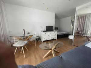 a living room with a glass table and chairs at Apartamento con piscina climatizada y vista al mar in San Bartolomé de Tirajana