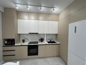 a kitchen with white cabinets and a sink at Rent Apartment in Bishkek