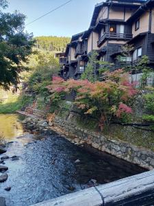 einem Fluss vor einem Gebäude neben einem Fluss in der Unterkunft Kurokawa Onsen Besso - Vacation STAY 14733 in Minamioguni