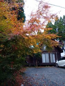 een huis met een auto ervoor geparkeerd bij Kurokawa Onsen Besso - Vacation STAY 14733 in Minamioguni