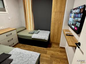 a small room with two beds and a flat screen tv at ADOME Apartment Nautico IV in Santa Pola