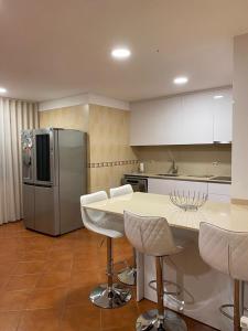 a kitchen with a table and a refrigerator at Casa da Leonor in Viseu