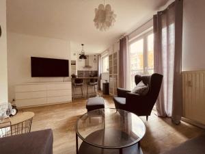 a living room with a couch and a table and a television at Exclusive Apartments, with Parking in Szczecin