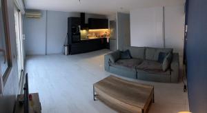 Una sala de estar con un sofá y una mesa de café. en Appartement 55m² avec vue sur Canigou et Parking, en Rivesaltes