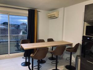 Un comedor con mesa y sillas y una ventana. en Appartement 55m² avec vue sur Canigou et Parking, en Rivesaltes 5 fotos más