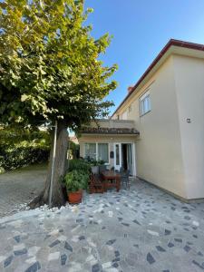 ein Haus mit einem Baum und einer Terrasse in der Unterkunft Rooms Krstinić 84 in Palit