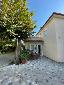 a house with a tree and a patio at Rooms Krstinić 84 in Palit
