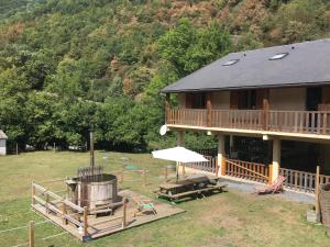 a large house with a grill and a picnic table at Les MARMOTTES pour 12 avec bain nordique privatif in Camous