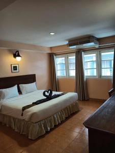 Nid Huahin Hotel في هوا هين: غرفة نوم بسرير عليها شريط أسود