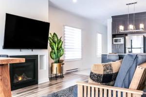a living room with a fireplace and a flat screen tv at ST-DO du LAC in Saint-Donat-de-Montcalm