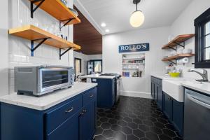 une cuisine avec des placards bleus et un four micro-ondes sur un comptoir dans l'établissement Oasis By the Sea, à Seaside 31 autres photos