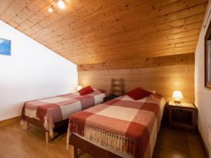 2 łóżka w pokoju z drewnianymi ścianami w obiekcie Appartement La Clusaz, 4 pièces, 6 personnes - FR-1-304-135 w mieście Clusaz