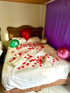 Una cama con rosas rojas y globos. en HOTEL RAYDON, en Estambul