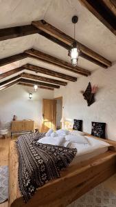 a large wooden bed in a room with wooden beams at Cuibul Braneanului in Bran