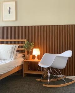 D'Houzz في سونغاي بيتاني: غرفة نوم مع كرسي أبيض بجانب سرير