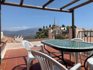 - une table et des chaises sur une terrasse avec vue dans l'établissement Casa Sin Numero, an authentic village house, à Comares