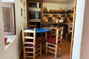 cocina con mesa y sillas en Casa Sin Numero, an authentic village house, en Comares