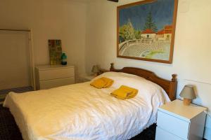 um quarto com uma cama com duas toalhas amarelas em Casa Sin Numero, an authentic village house em Comares
