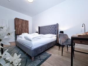 een slaapkamer met een bed, een tafel en een bureau bij Alpha Apartments in Dortmund