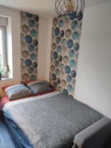 a bedroom with a bed with a wall of logs at Appartement cosy centre-ville wifi parking in Charleville-Mézières