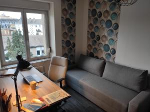 un soggiorno con divano e tavolo di Appartement cosy centre-ville wifi parking a Charleville-Mézières